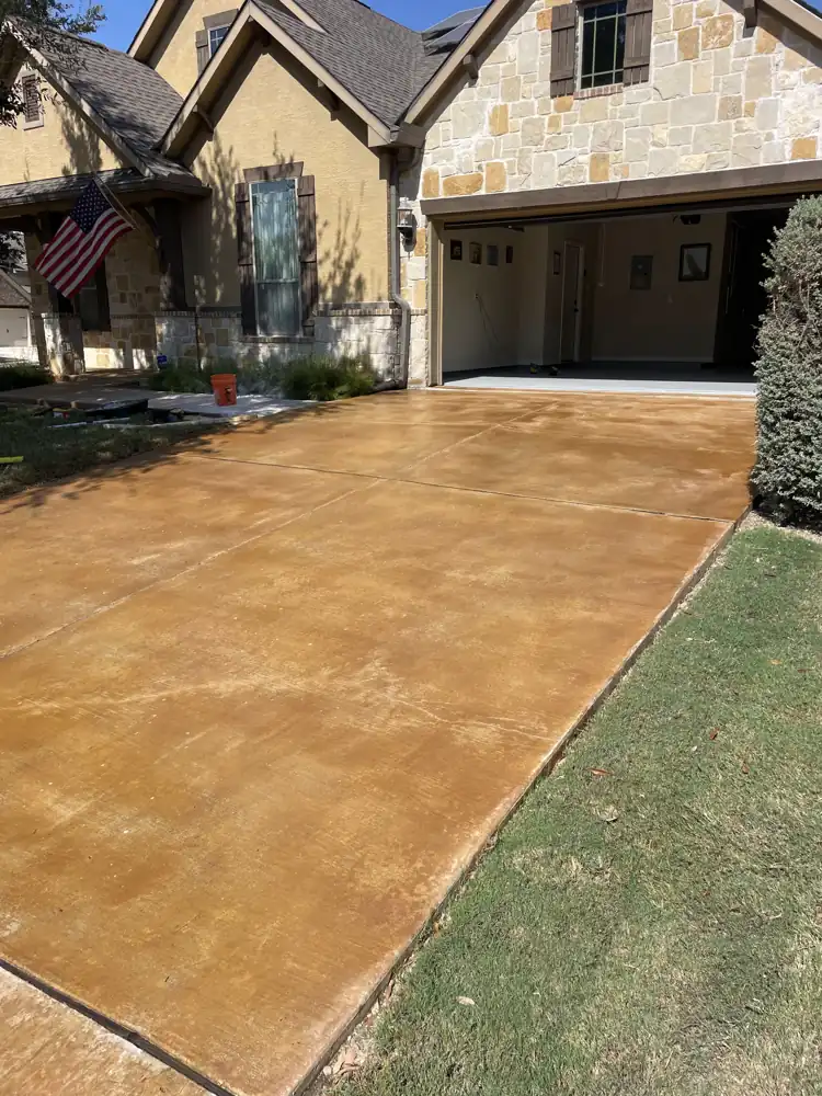 Stained concrete driveway leading to a garage