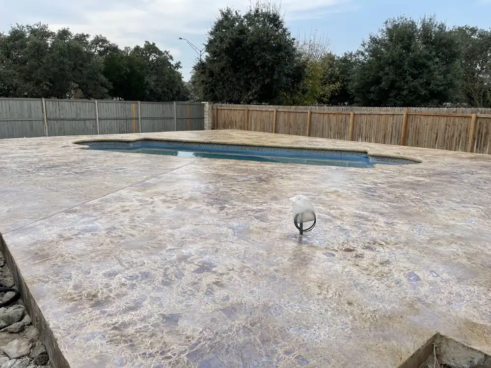 Stained concrete pool deck around a pool